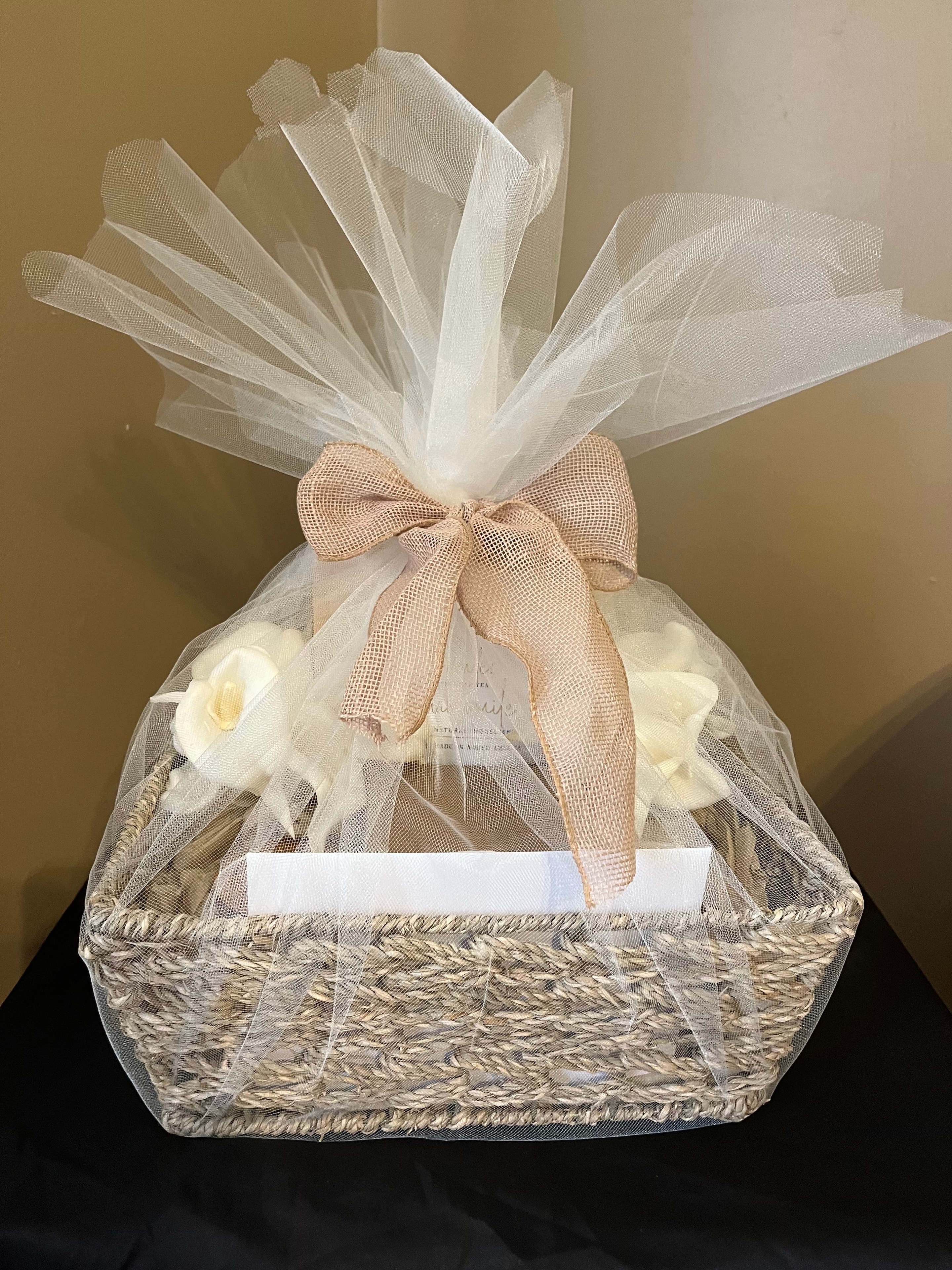 A grief basket with soft white flowers and ribbon